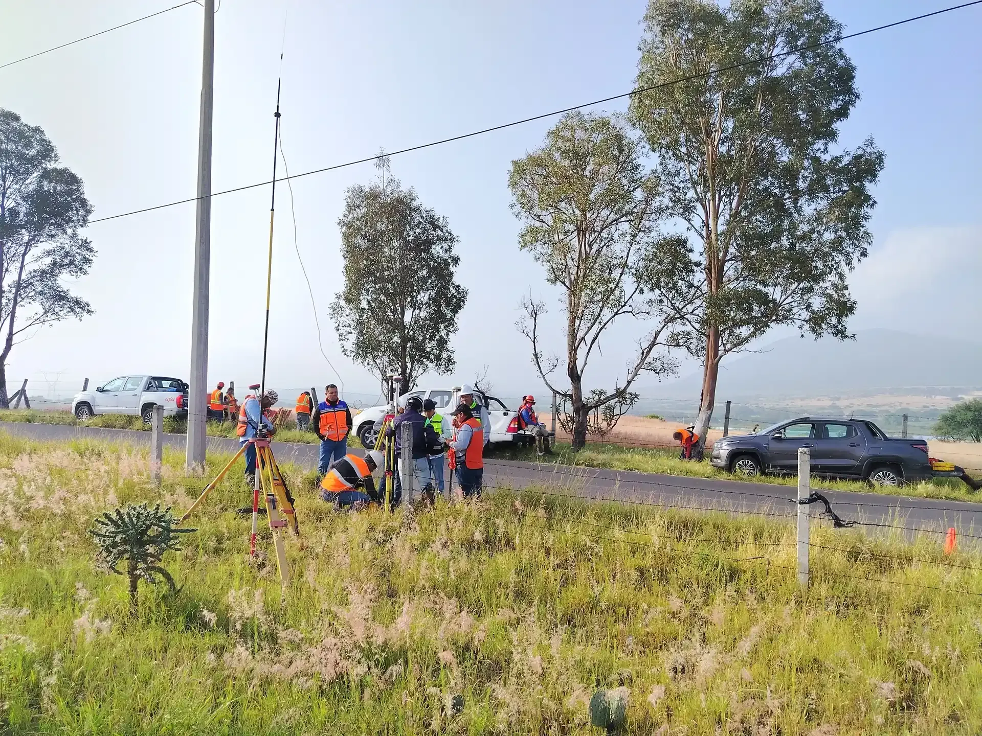 Brigada de topografía llegando al frente con camionetas junto a la carretera