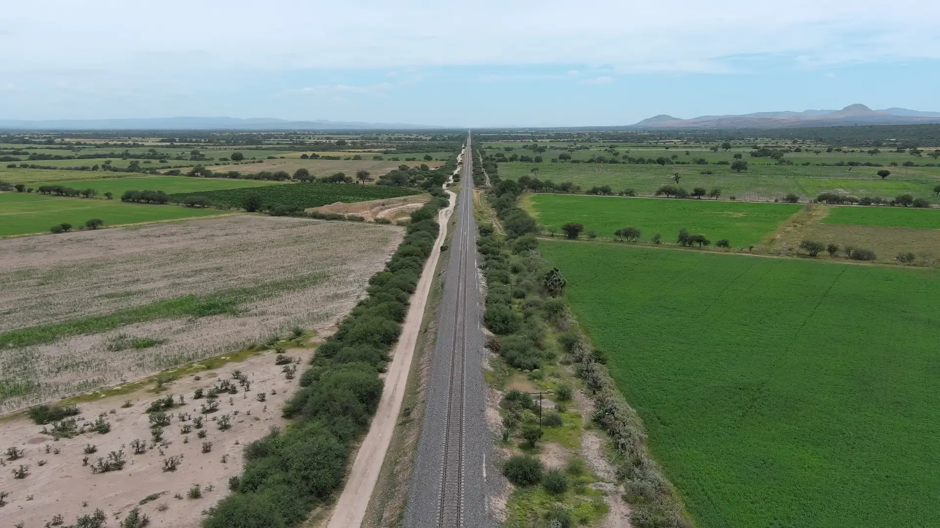 Vía férrea entre campos vista desde dron