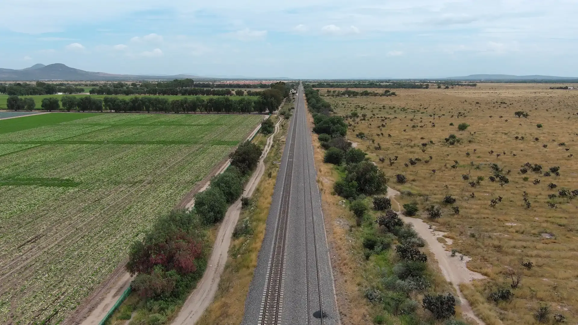 Vía férrea entre parcelas, fotografía aérea 4K